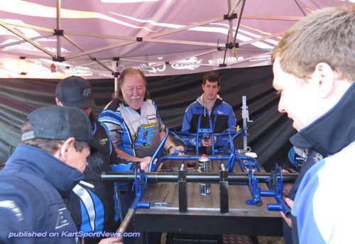 Daniel Kinsman (front of kart) watching the CRG team members manipulate his kart's bent frame back into shape on their special mobile jig