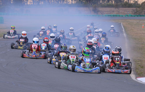 The field of Rookies race into turn one at the Hume International Karting Raceway, Jordan Caruso (12) on the inside of Cooper Murray (16) ahead of Thomas Hughes (48) and Cody Brewczynski (18)